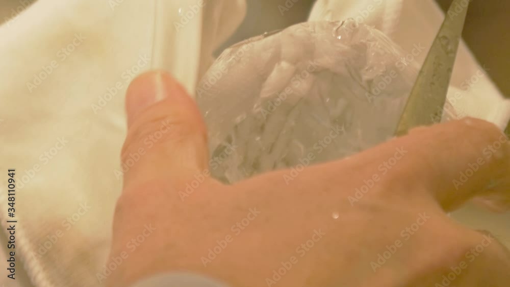 close up of man carving ice cube with a knife - static close up of man carving ice cube with a knife - static