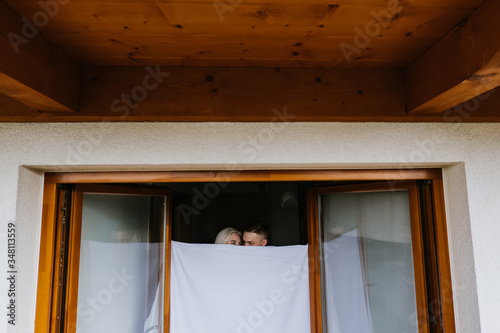 Young man and woman in sheets on the balcony.