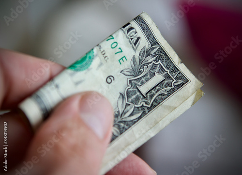 Mans hand offering a dollar bill