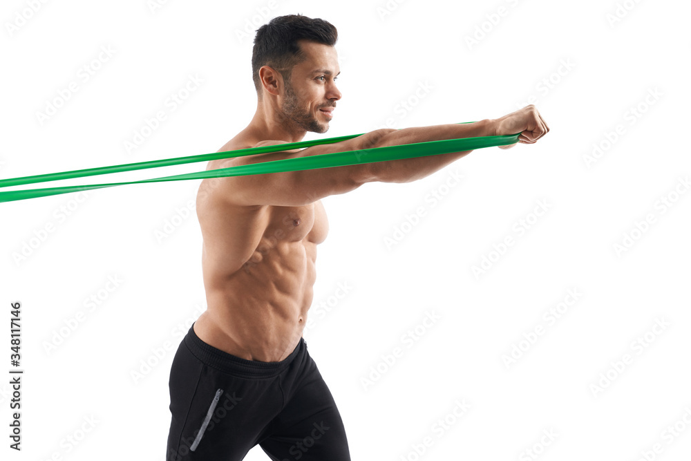 Shirtless bodybuilder using resistance band.