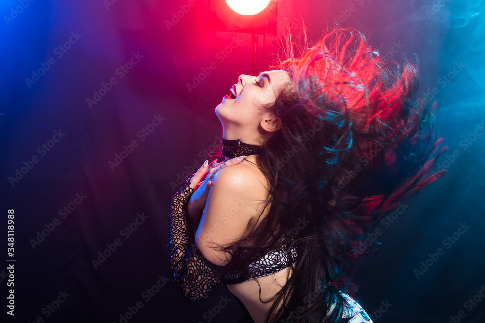 Young woman belly dancer in exotic dress with gold, dancing tribal fusion dance in studio.