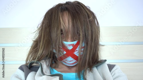 4K Lockdown isolation selfies - Protesting female with bloody crossed mask and hair covering her face
 photo