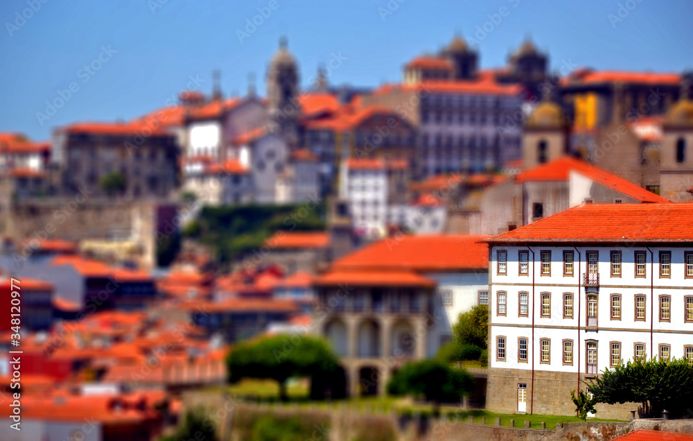 Porto, Portugal - August 16, 2015: Cityscape of Porto in summer, with a good weather. This city is built along the river Douro, which goes to the sea. Focus on a building with tilt-shift effect.