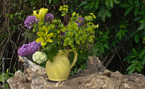 Blumenstrauß in der gelben Vase. Tulpen, Flieder, Wolfsmilch, Kugeldistel, Schneeball.