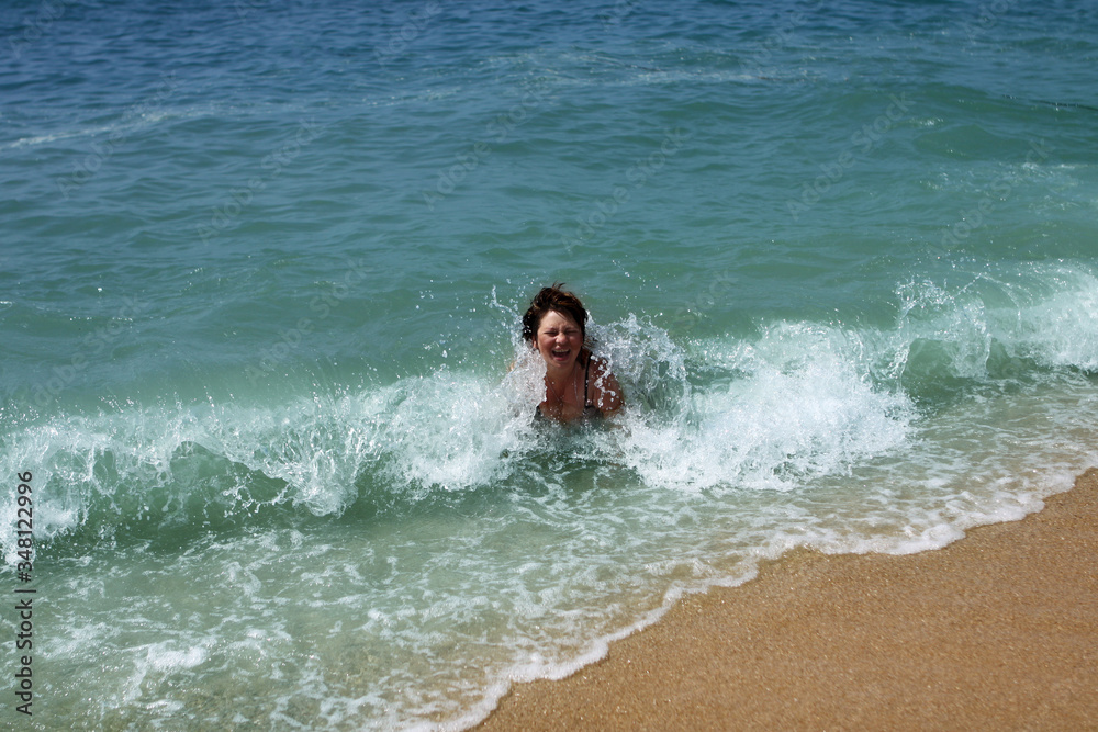 woman bathes in the waves on the seashore in a storm, concept of vacation, trip woman bathes in the waves on the seashore in a storm, concept of vacation, trip