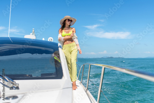 Luxury travel on the yacht. Young woman enjoying the sunny days on the yacht in the sea.