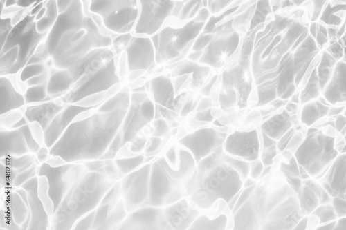 Closeup of desaturated transparent clear rough water surface texture with splashes and bubbles. Trendy abstract nature background. 