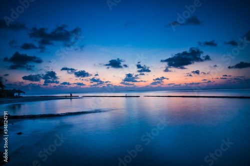 Alba blu con nuvole all   orizzonte  viste da un atollo ai bordi dei reef nel mare delle Maldive