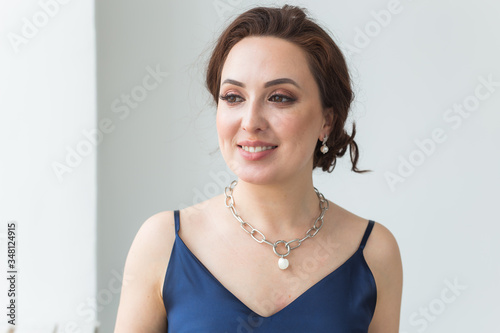 Close-up portrait of beautiful young woman with elegant hairstyle and luxurious jewelry and bijouterie.