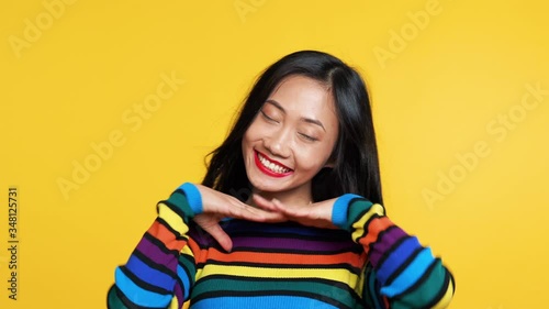 Pretty asian woman posing on yellow background