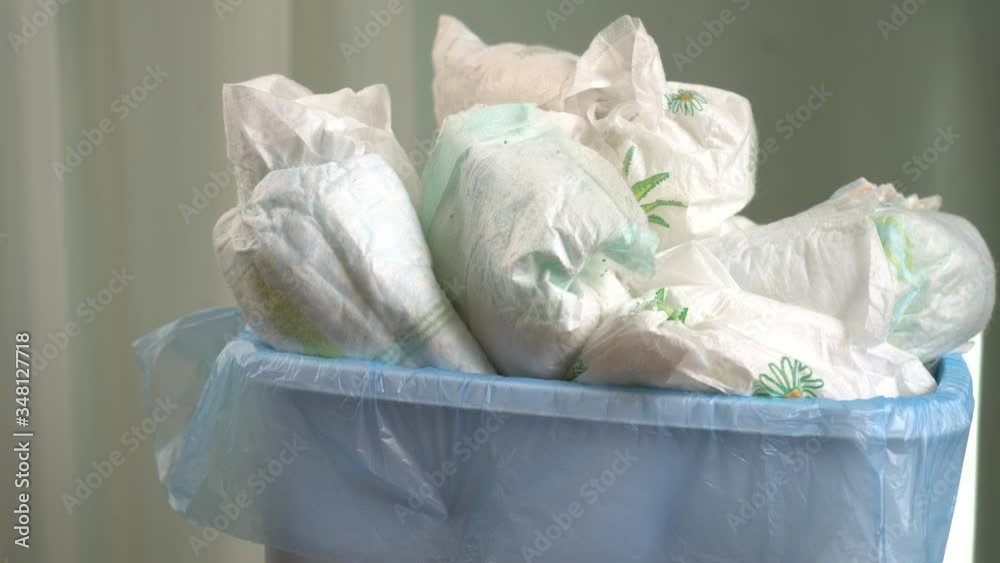 Trash can in the bathroom with used dirty disposable nappies. Old