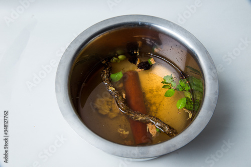 a preparation for a hot cup of ayurvedic medicin called kadha  with lot of herbs for safeguard against corona virus to prevent covid 19, also to prevent cold, cough, infulenza and boost immunity photo