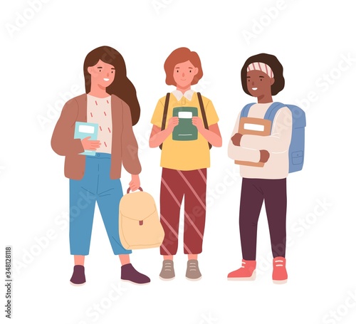 Group of adorable diverse classmates girls standing together vector flat illustration. Happy female pupils friends smiling holding books and backpacks isolated on white. Joyful kids mate