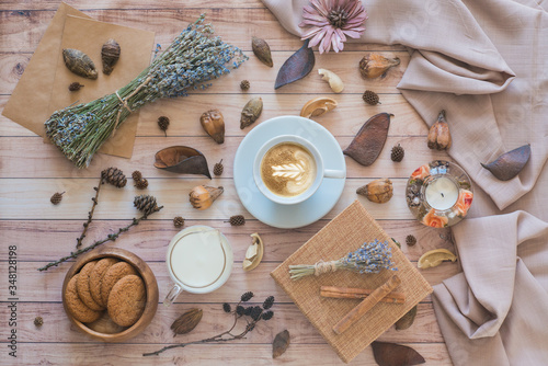 Cup of cappuccino with latte art on wooden background. Autumn flat lay composition. Cozy breakfast. Top view
