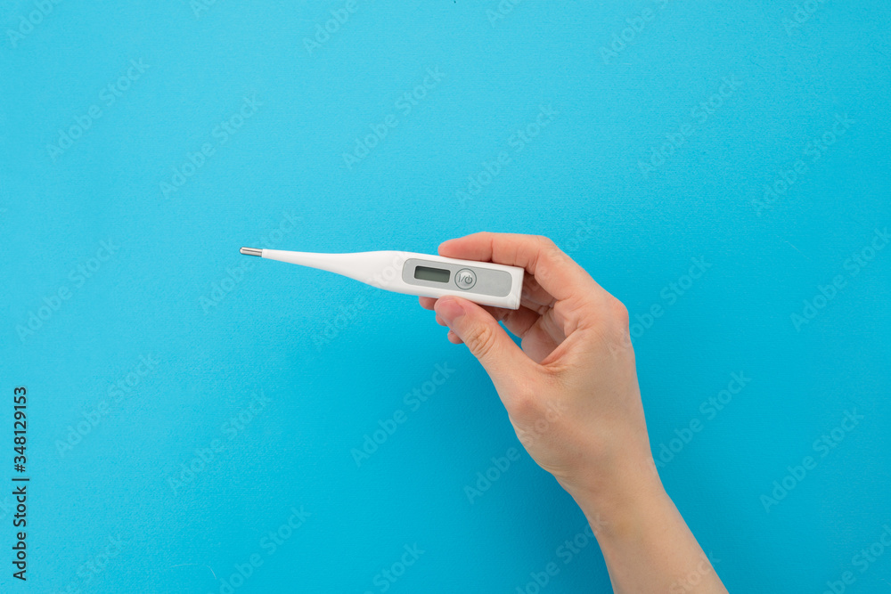 Top view of one single thermometer in hand. Electronic device for measuring the temperature of the human body Top view of one single thermometer in hand. Electronic device for measuring the temperature of the human body