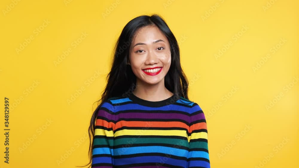 Happy amazed woman saying yes and rejoices good news on yellow background Happy amazed woman saying yes and rejoices good news on yellow background