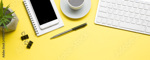 White desk office with laptop, smartphone and other work supplies with cup of coffee. Top view with copy space for input the text. Designer workspace on desk table essential elements on flat lay