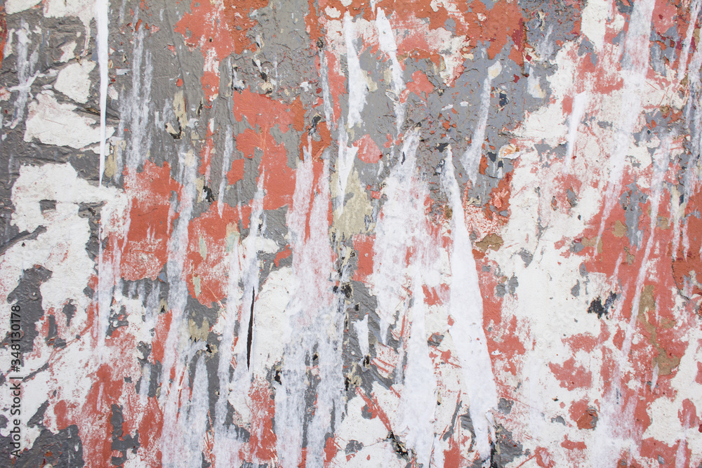 Old dirty urban wall with torn paper posters, peeling paint and damaged surface texture background. Old dirty urban wall with torn paper posters, peeling paint and damaged surface texture background.