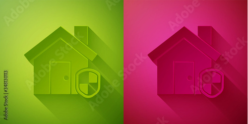 Paper cut House under protection icon isolated on green and pink background. Home and shield. Protection, safety, security, protect, defense concept. Paper art style. Vector