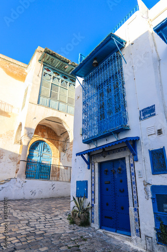 Edificios blancos con puertas y ventanas azules típicas del mediterráneo en una calle de Túnez en África © Jennifer