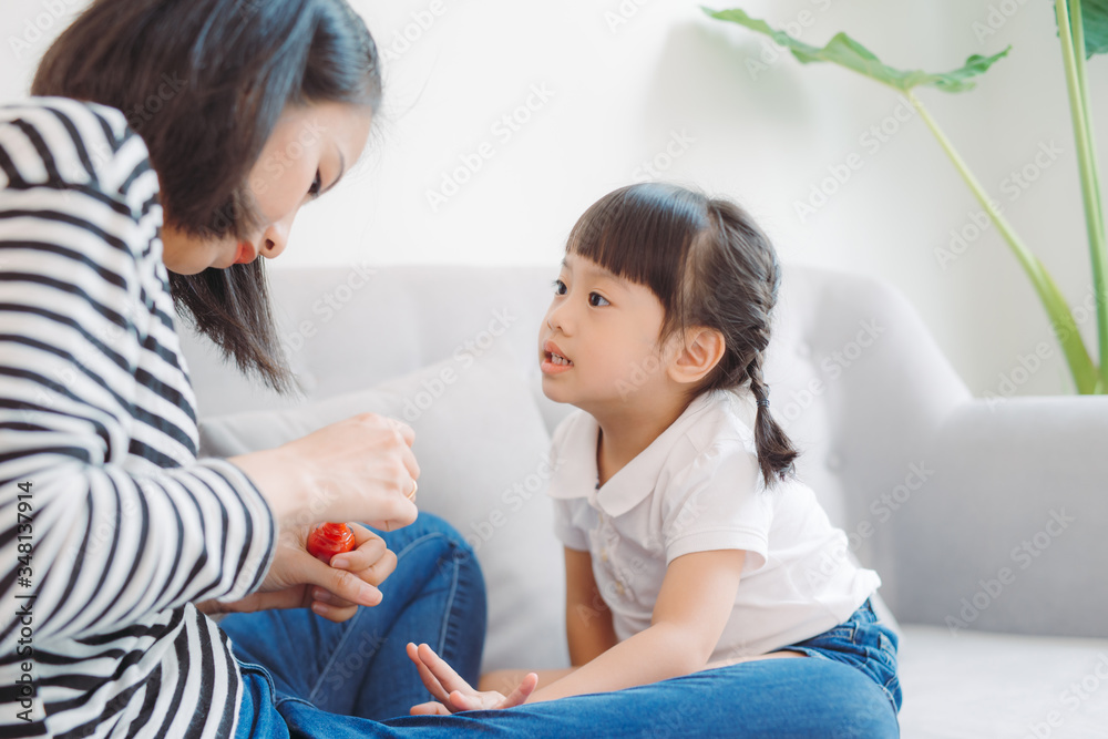 Mother and daughter painting their finger nails with polish Mother and daughter painting their finger nails with polish