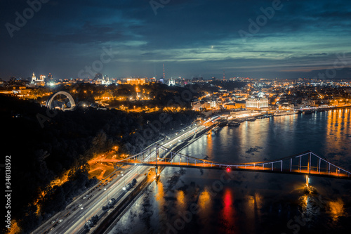 night cityscape. aerial view. colorful led bridge across river and quay road in Kyiv