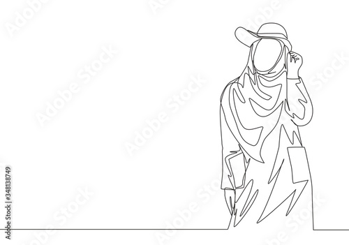 One single line drawing of young happy beauty muslimah wearing cute hat and pose nicely. Beautiful Asian woman model in trendy hijab fashion concept continuous line draw design vector illustration