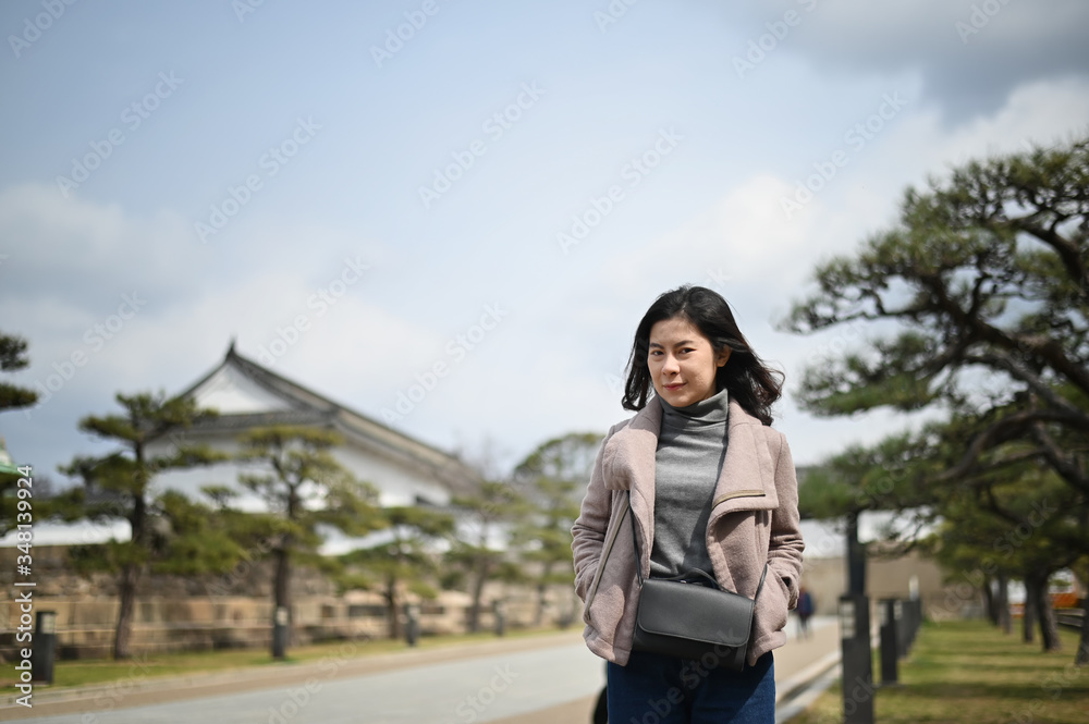 Traveller female posting on castle Osaka Japan, Portrait shot with travel trip.