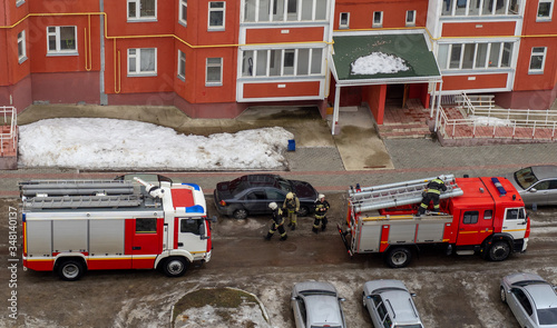 Fire engine in the courtyard of a multi-storey residential building in winter. photo