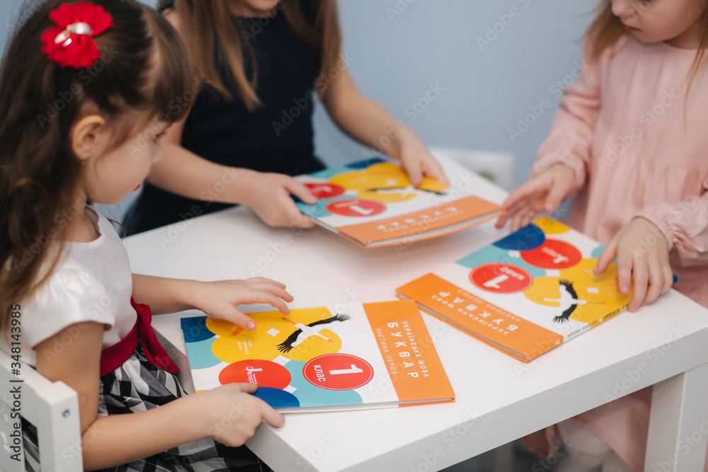 Close-up of children study in preschool. Smart kids in class. Girl read book Close-up of children study in preschool. Smart kids in class. Girl read book