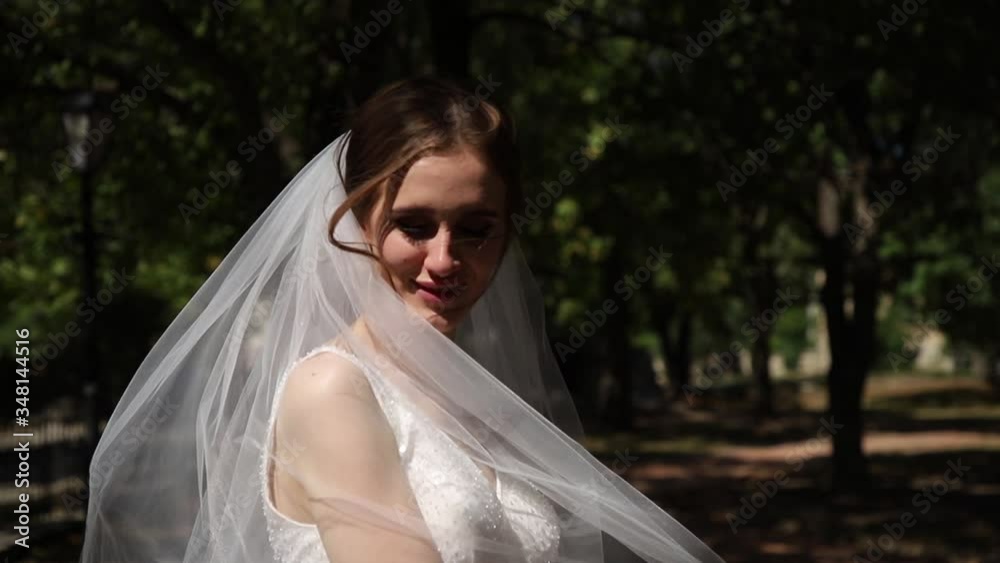 The bride poses for the camera with a veil. The bride poses for the camera with a veil.