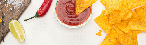 top view of corn nachos with lime, chili, ketchup on white background, panoramic shot