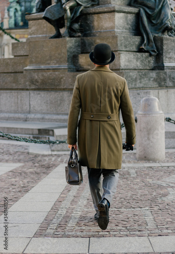 Men wearing elegant clothes walking in Main square in Krakow
