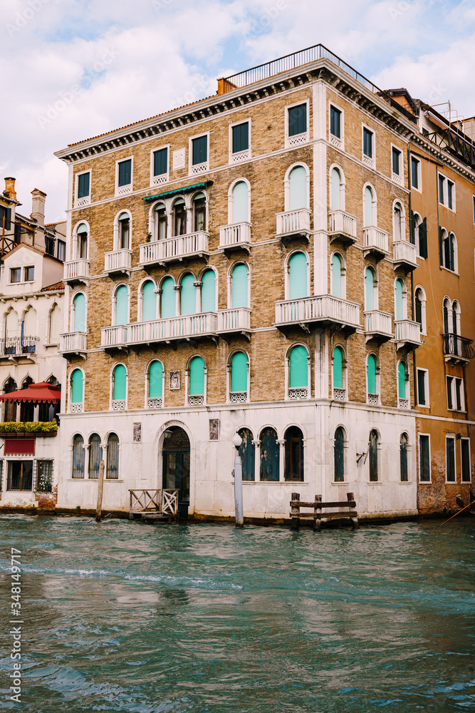 Old houses on Grand Canal, Venice, Italy. Vintage hotels and residential buildings in the Venice center. Historical architecture of Venice on water in summer. Venetian street with ancient facades.