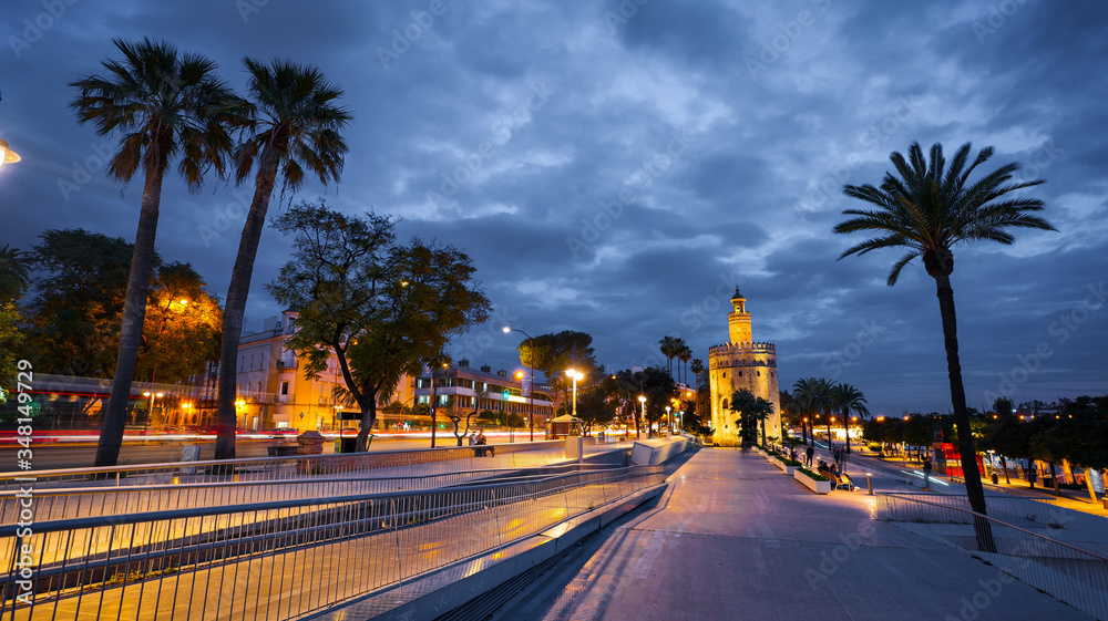 Seville, Spain - February 18th, 2020 - Torre del Oro / Golden Tower and Guadalquivir river at blue hour in Seville City, Spain.
