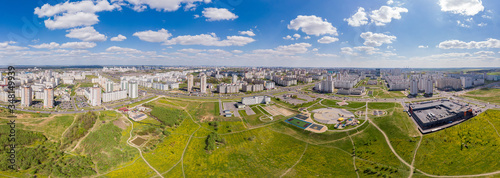 Aerial drone shoot with top view of Minsk, Belarus. Modern architecture, road, cars traffic and trees, blue sky. Sun shining. Panorama 180 degrees
