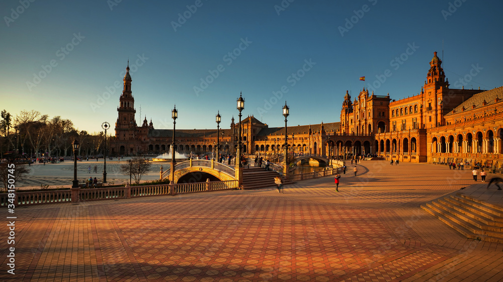 Seville, Spain - February 20th, 2020 - Tourists strolling in Plaza de Espana with Architecture Details at sunset in Seville City Center.
