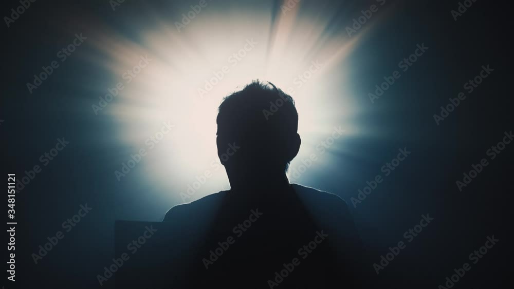 Silhouette of a woman watching a movie on a screen