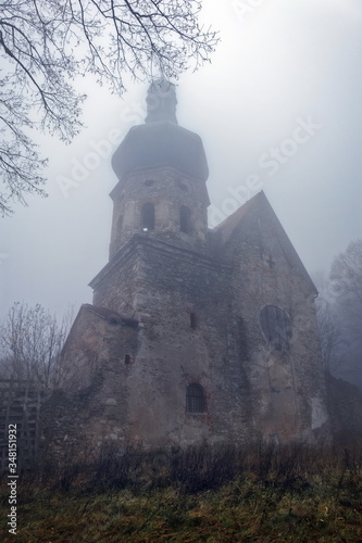 Abandoned and decayed church in the fog