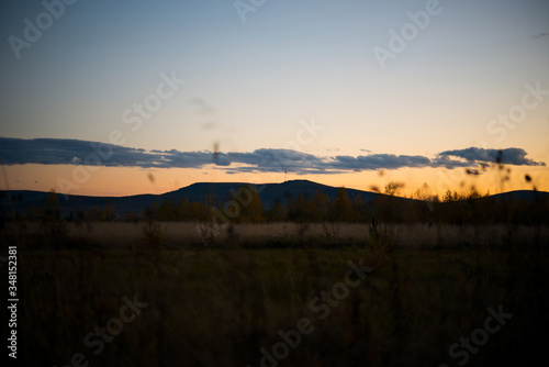 Evening landscape at sunset, warm sunlight over the field, Ural, September