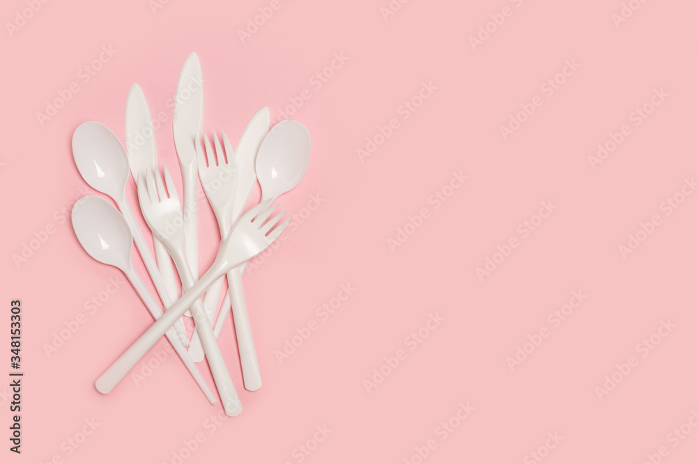 Cuchillo, tenedor y cuchara de plástico blanco desechable sobre fondo rosa liso y aislado. Vista superior. Copy space Cuchillo, tenedor y cuchara de plástico blanco desechable sobre fondo rosa liso y aislado. Vista superior. Copy space