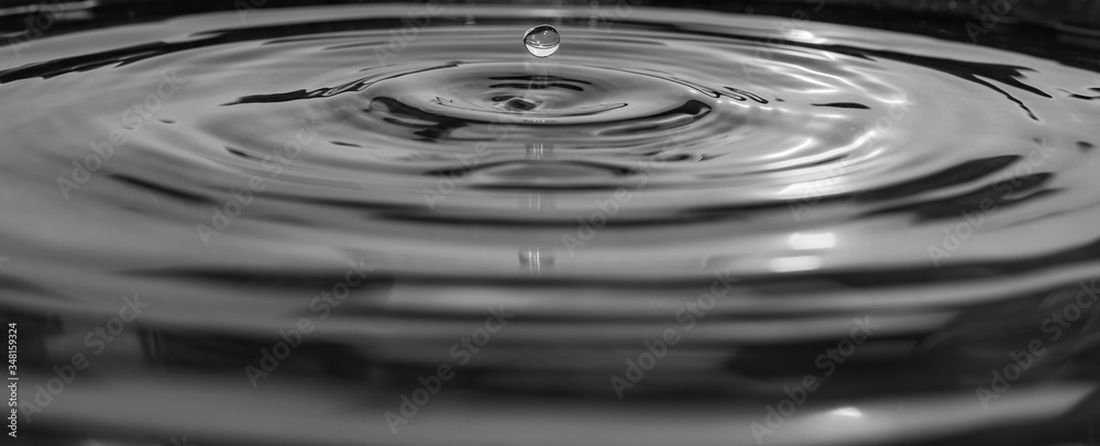 Wassertropfen fallen in das wasser mit kleinen wellen schwarz weiss –  Stock-Foto | Adobe Stock