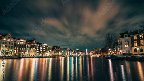 Amsterdam canal, Amstel river with city illumination reflection, Netherlands, Dutch city at night. © DedMityay