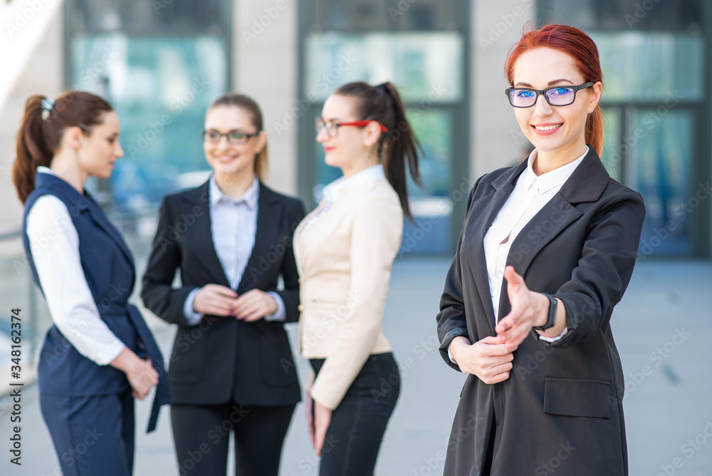 Portrait of a young and successful business woman who holds out her hand Portrait of a young and successful business woman who holds out her hand