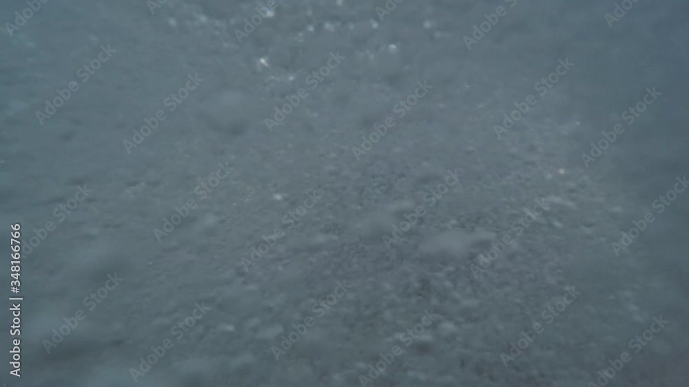 Young man hardly breathes in rough sea. Clip has underwater views