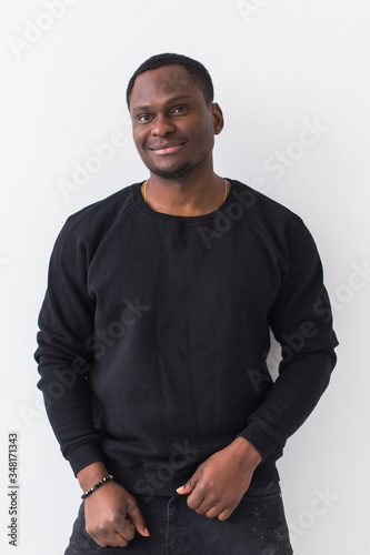 Youth street fashion concept - Portrait of confident sexy black man in stylish sweatshirt on white background.