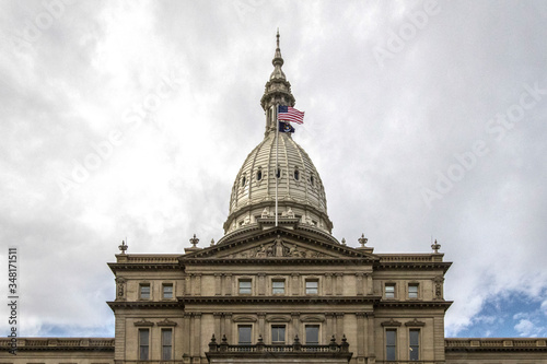 Close up of the exterior of the Michigan State Capitol Building rotunda with the American and Michigan flag. 