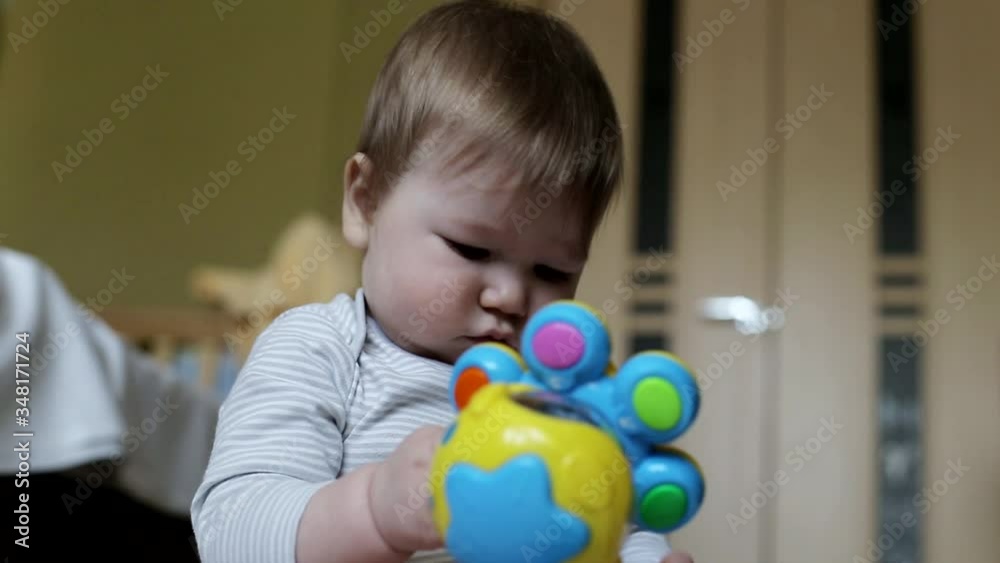 Little beautiful baby boy is played with toys at home. 8 month old boy, caucasian. Big brown eyes Little beautiful baby boy is played with toys at home. 8 month old boy, caucasian. Big brown eyes