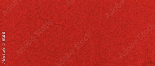 Bright red texture of knit fabric. Red textile background with natural folds. Close-up