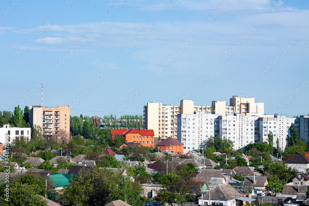 Photo of the city panorama  from the roof of a residential building (9th floor) in spring. There are many trees and several multistorey houses